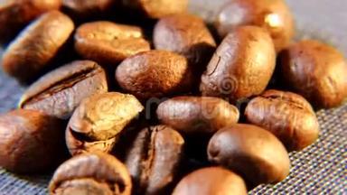 棕色的芳香咖啡颗粒在桌子上<strong>粗布</strong>的基材上旋转。
